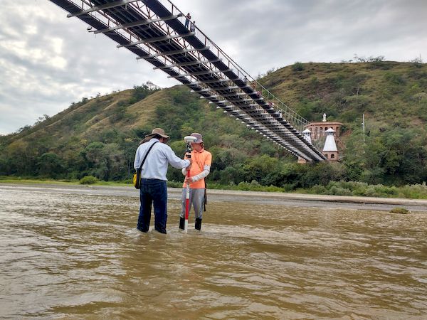 Equipo de INCIGE realizando medicion en zona de agua bajo un puente