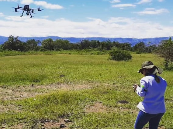 Operadora controlando dron en campo abierto